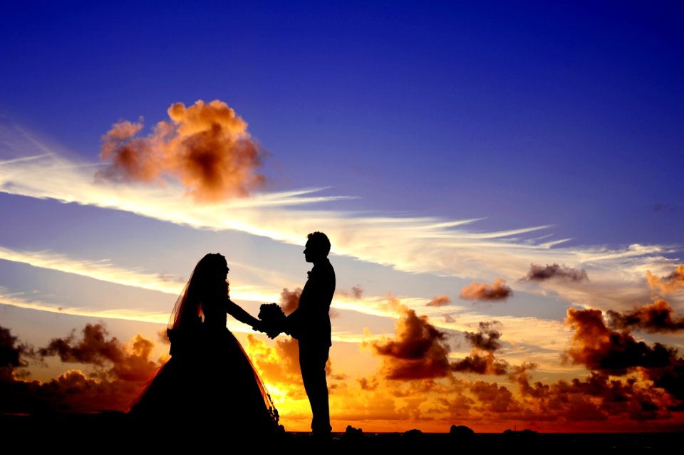 Silhouette Of Wedding Couple Holding Hands Under Cloudy Blue Sky