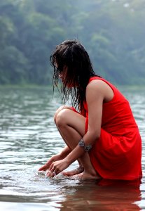 Woman In Red Dress Crouching In Lake photo