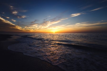 Waves Breaking On Beach At Sunset photo