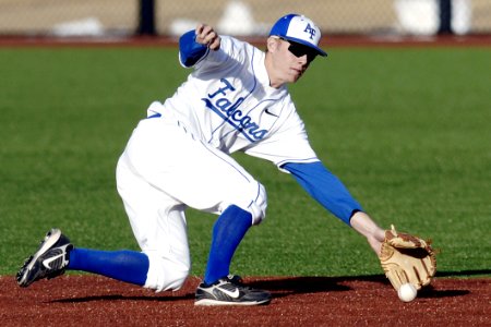 Man Wearing Blue And White Falcons Baseball Jersey Shirt With Brown Baseball Gloves Catching White Baseball photo