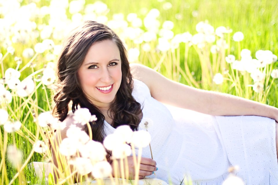 Woman In White Sleeveless Dress Lying On Green Grass Field photo