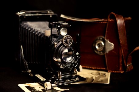 Black Classic Camera Near Brown Leather Bag photo