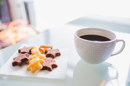 White Tea Cup Beside White Square Saucer With Star Shaped Cookies photo