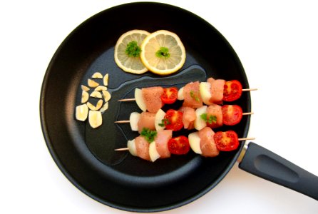 Barbecue Stick Beside Lemon On Black Frying Fan