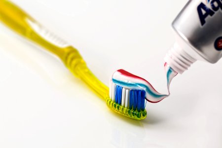Toothpaste Being Put On Yellow Toothbrush photo