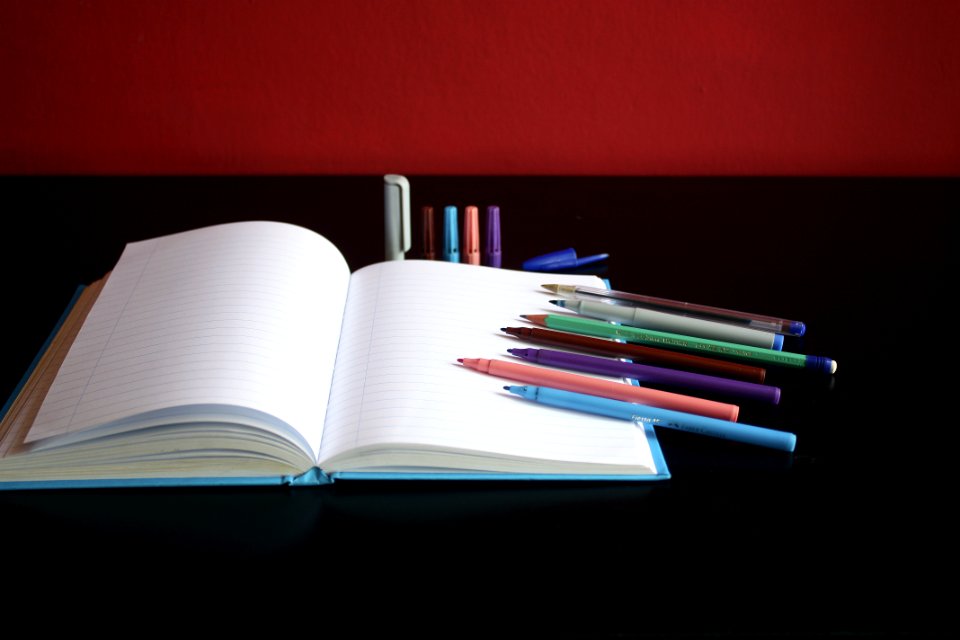 Blank Notebook Beside Color Pens