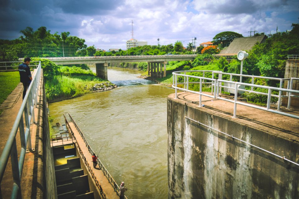 Man Standing By White Railing Near River