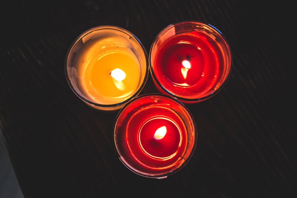 Lighted Red Wax Candle On Clear Drinking Glass