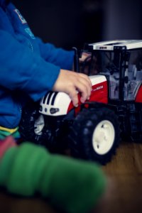 Child Playing With Toy Tractor