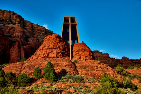 Tower of the Chapel of the Holy Cross in Sedona, Arizona, a small city and popular tourist attraction thanks to its red sandstone formations, which glow brilliant orange or red when illuminated by the rising or setting sun. The Roman Catholic chapel, which rises among these formations, was commissioned by local rancher and sculptor Marguerite Brunswig Staude, who had been inspired in 1932 by the newly constructed Empire State Building to build such a church. After an attempt to do so in Budapest, Hungary, was aborted due to the outbreak of World War II, she decided to build the church in her native region. Original image from Carol M. Highsmith’s America, Library of Congress collection. photo