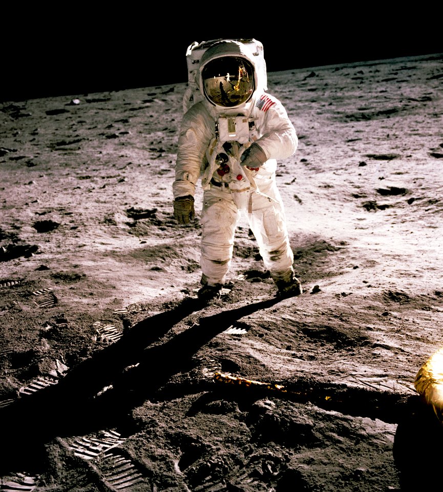 Edwin Aldrin walking on the lunar surface. Neil Armstrong, who took the photograph, can be seen reflected in Aldrin’s helmet visor.