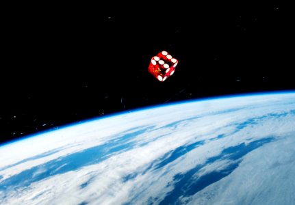 A dice floating in front of one of the windows in the Cupola of the Earth-orbiting International Space Station. photo