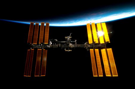 The International Space Station backdropped by Earth’s horizon and the blackness of space.