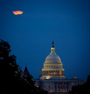 A perigee full moon or supermoon is seen behind clouds over the United States Capitol, Sunday, August 10, 2014, in Washington.