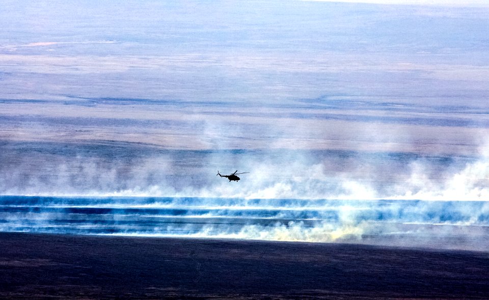 A Russian search and rescue helicopter flies over the burning Kazakh steppe.