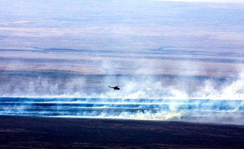 A Russian search and rescue helicopter flies over the burning Kazakh steppe. photo