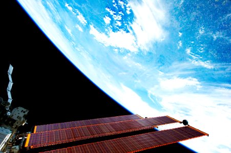 International Space Station solar array panels and a blue and white part of Earth are featured in this image photographed by an STS-134 crew member onboard the station during flight day six activities, 21 May 2011. photo