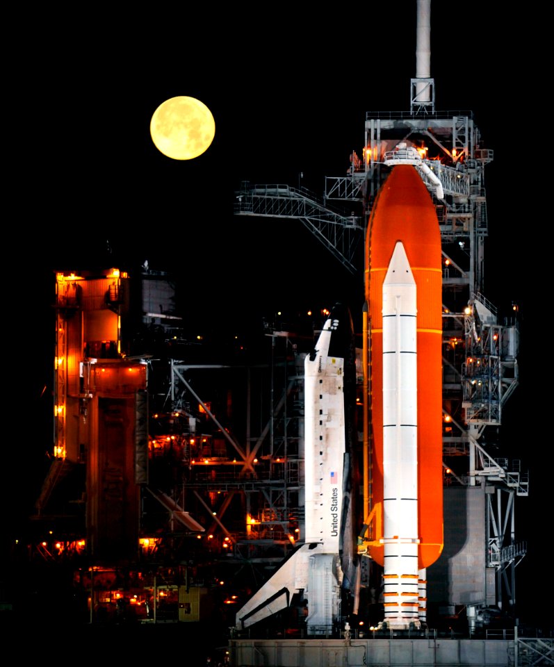 A nearly full Moon sets as the space shuttle Discovery sits atop Launch pad 39A at the Kennedy Space Center in Cape Canaveral, Florida, March 11, 2009.