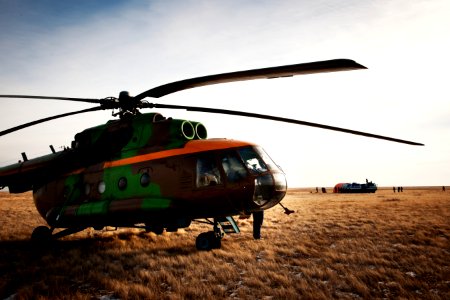 Russian Search and Rescue helicopter and crew await the arrival of an all-terrain vehicle. photo