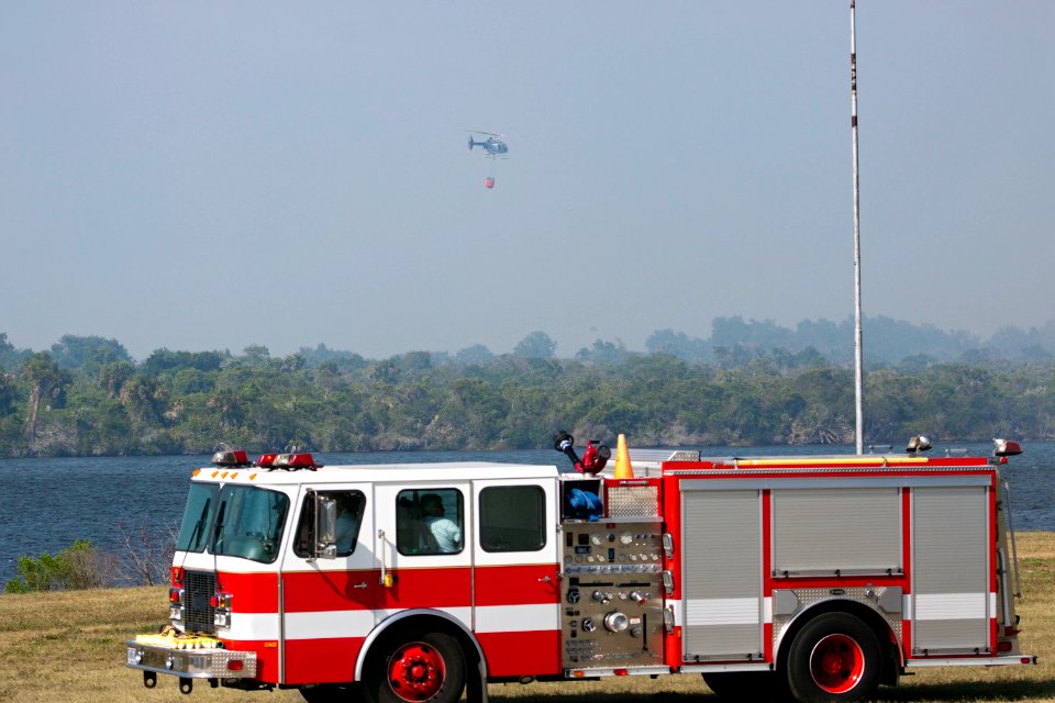 At NASA's Kennedy Space Center in Florida, a helicopter collects water from the Turn Basin to douse a nearby brush fire, 27 April 2011.
