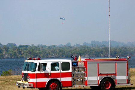 At NASA's Kennedy Space Center in Florida, a helicopter collects water from the Turn Basin to douse a nearby brush fire, 27 April 2011.