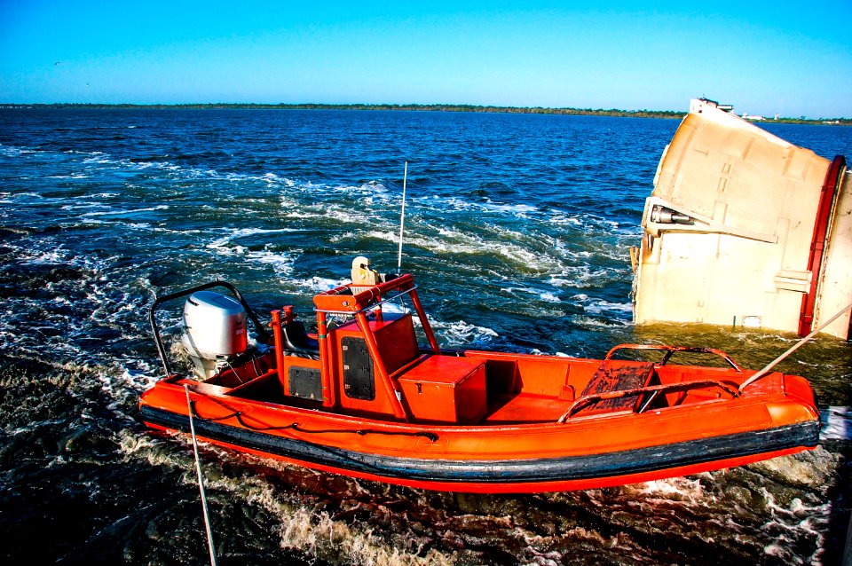 A skiff from Freedom Star, one of NASA's solid rocket booster retrieval ships, helped usher a spent shuttle booster through the shallow waters of the locks at Port Canaveral, Fla.