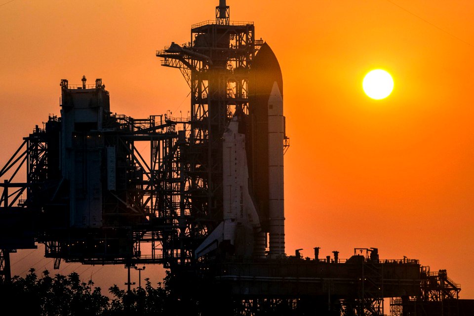 Space shuttle Atlantis, attached to its bright-orange external fuel tank and twin solid rocket boosters on Launch Pad 39A at NASA's Kennedy Space Center in Florida.