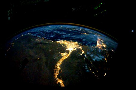 Night time photo featuring the bright lights of Cairo and Alexandria, Egypt on the Mediterranean coast. The Sinai Peninsula, at right, is outlined with lights highlighting the Gulf of Suez and Gulf of Aqaba.