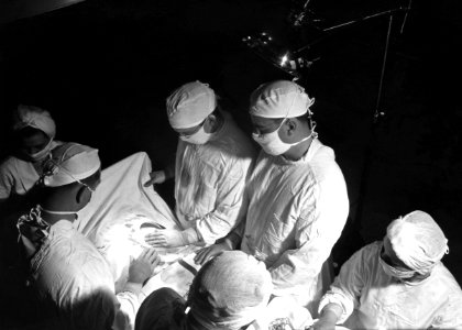 The 1950s historical photograph of the inside of an operating room suite during a surgical procedure. Original image sourced from US Government department: Public Health Image Library, Centers for Disease Control and Prevention. Under US law this image is copyright free, please credit the government department whenever you can”. photo