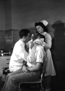 The 1950s historical photograph of an industrial plant physician and nurse examining the eye of an industrial plant worker. Original image sourced from US Government department: Public Health Image Library, Centers for Disease Control and Prevention. Under US law this image is copyright free, please credit the government department whenever you can”.
