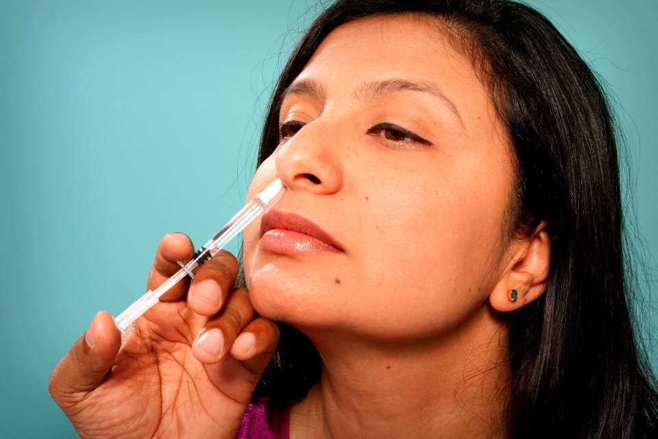 A healthcare practitioner administering the H1N1 live attenuated intranasal vaccine (LAIV) to a female recipient. Original image sourced from US Government department: Public Health Image Library, Centers for Disease Control and Prevention. Under US law this image is copyright free, please credit the government department whenever you can”.