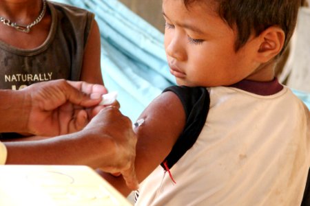 A Cambodian boy receiving his injection of measles vaccine. Original image sourced from US Government department: Public Health Image Library, Centers for Disease Control and Prevention. Under US law this image is copyright free, please credit the government department whenever you can”.