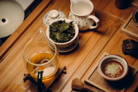 White Ceramic Teapot Beside Cup With Leaves photo