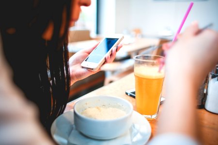 Human Holding Iphone Infront On White Round Bowl photo