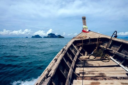 Brown Wooden Boat On Sea Overlooking Rocky Island