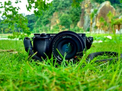 Black Sony Dslr Camera On Green Grass In Front Of Brown And Green Mountain photo