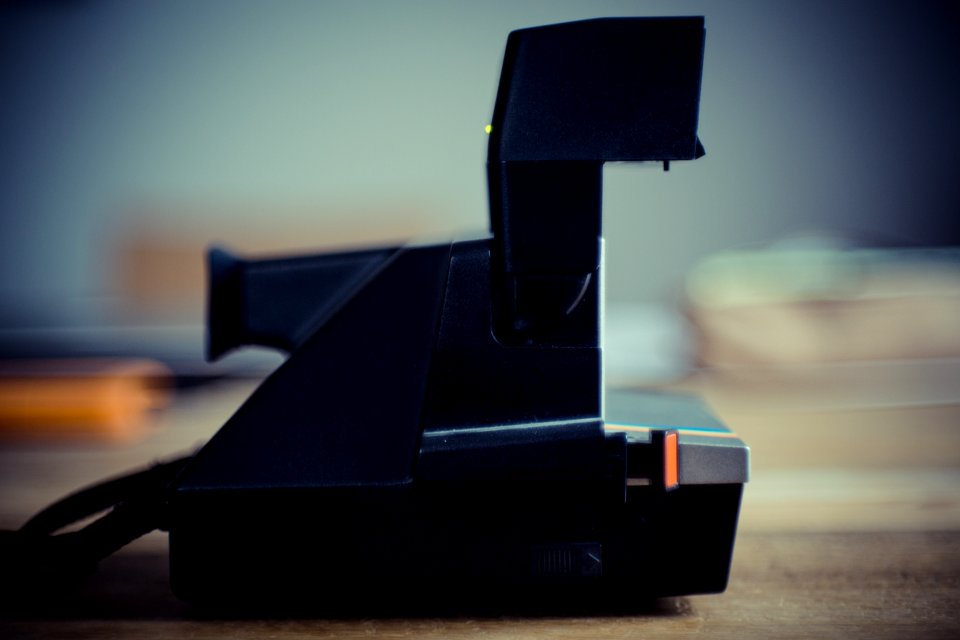 Black And Gray Instant Camera On Brown Wooden Table