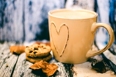 Beige Ceramic Heart Mug With Coffee Beside Cookie Food photo