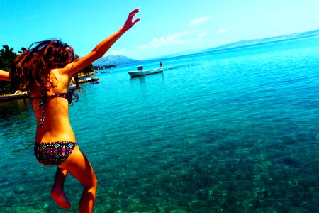 Woman Wearing Bikini Jumping To The Beach photo