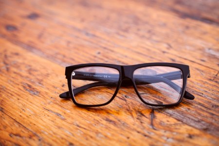Black Frame Wayfarer Eyeglasses On Brown Wooden Surface photo