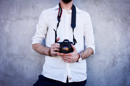 Man Wearing White Long Sleeves Holding Black Canon Dslr Camera photo