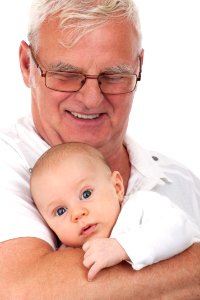Man In Black Frame Eyeglasses Carrying A Baby photo