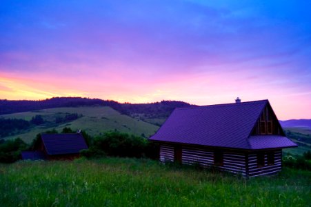 Wooden Cottage In Field At Sunset photo