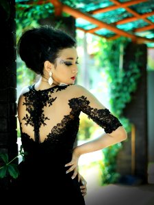 Woman In Black Dress Near Green Vines