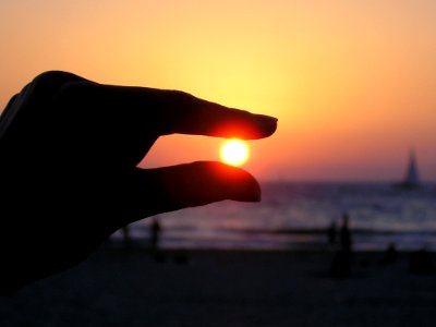 Force Perspective Photo Of Person Holding Sun photo