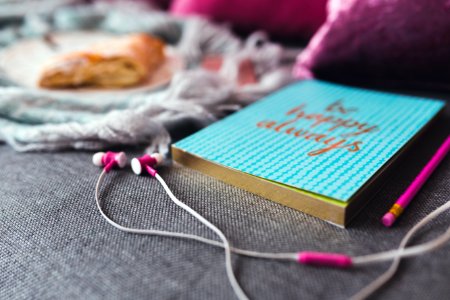 White And Pink Earphones On Gray Textile