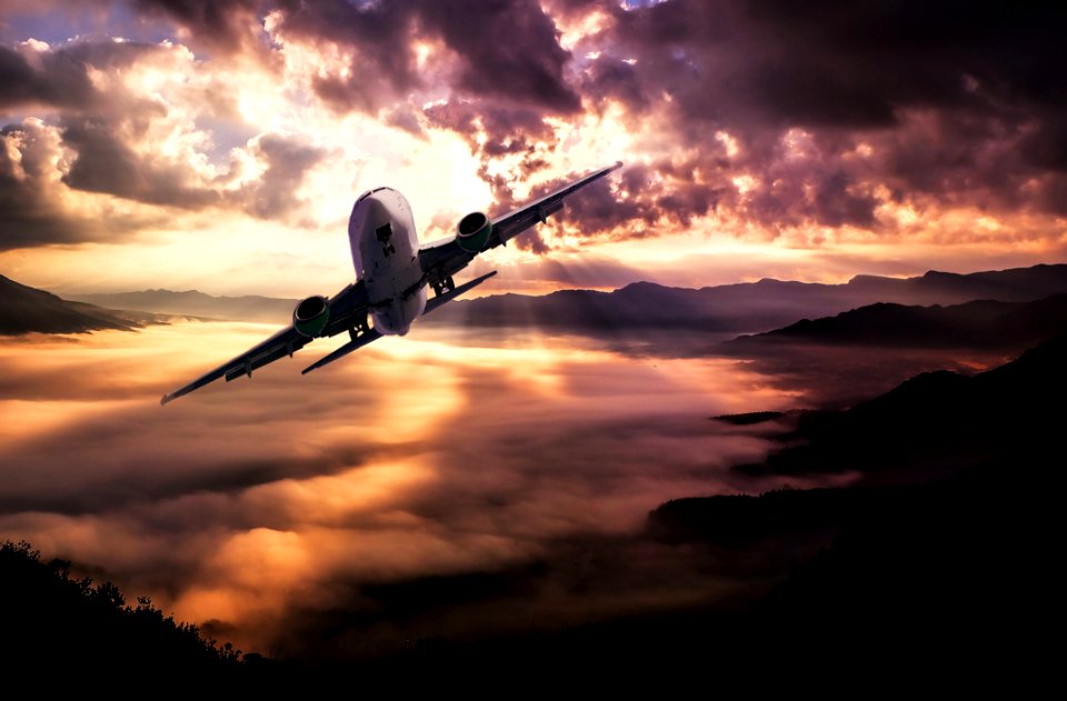 Airplane Flying Under White Clouds During Night Time