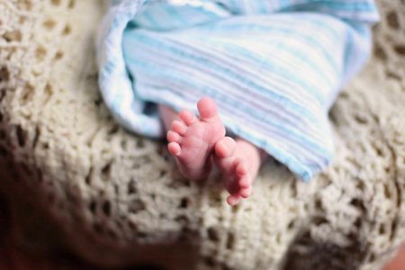 Baby Feet Underneath A Blue Blanket