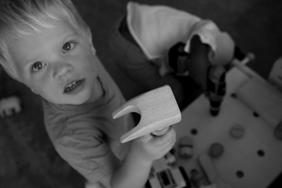 Greyscale Photo Of Boy On Tshirt Holding Brown Wood photo