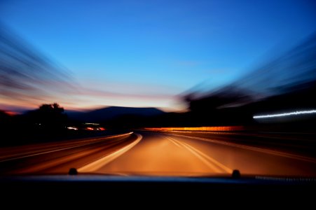 Car Driving On Road At Sunset